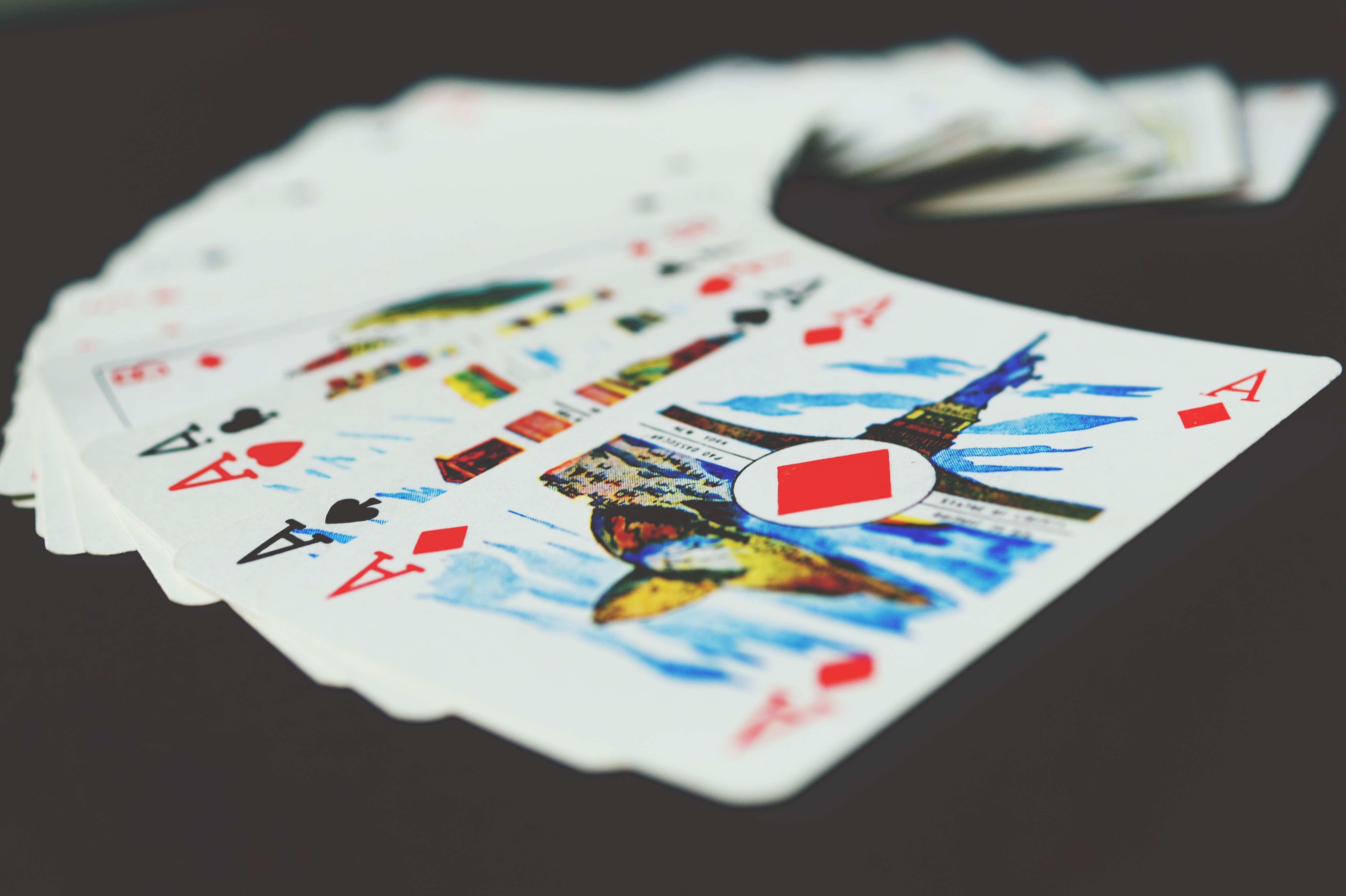 a set of playing cards with aces of different types visible and other cards blurred in the background. A magician often uses playing cards