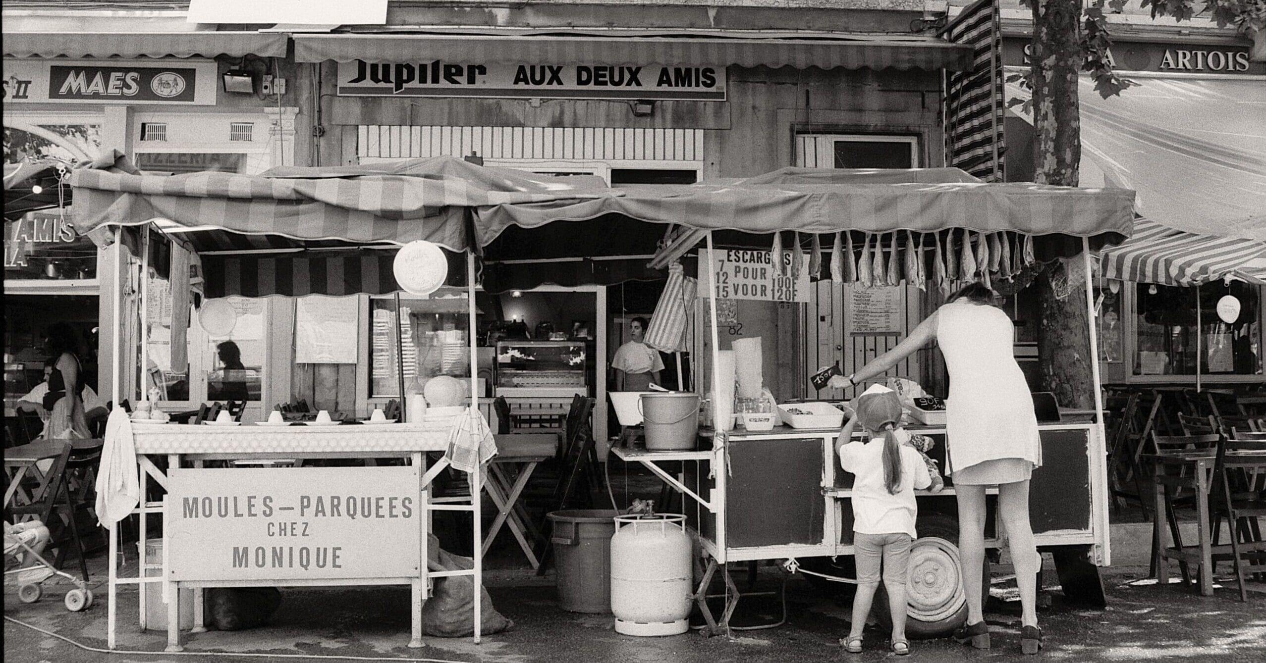 black and white photo of a woman-with-her-daughter-shopping-at-a-fish-stand