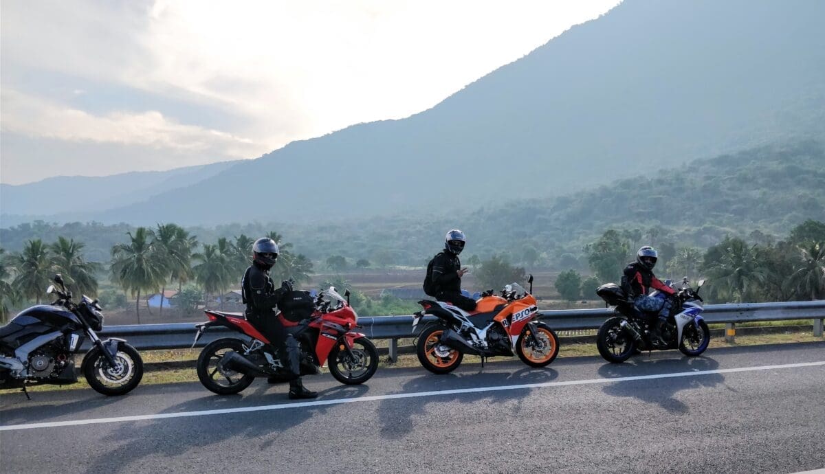 A group of motorcyclists parked on a road in front of a mountain. Outlaw is commonly associated with motorcyclists