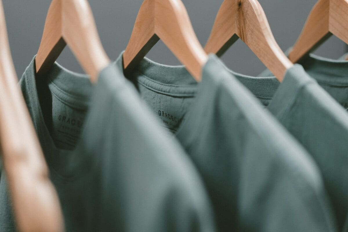 clothes hangers with multiple grey t shirts, an everyman attire